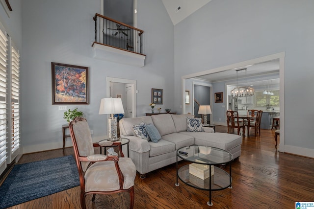 living room featuring a wealth of natural light, an inviting chandelier, dark hardwood / wood-style floors, and high vaulted ceiling