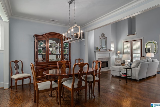 dining room with dark wood-type flooring, crown molding, and a chandelier