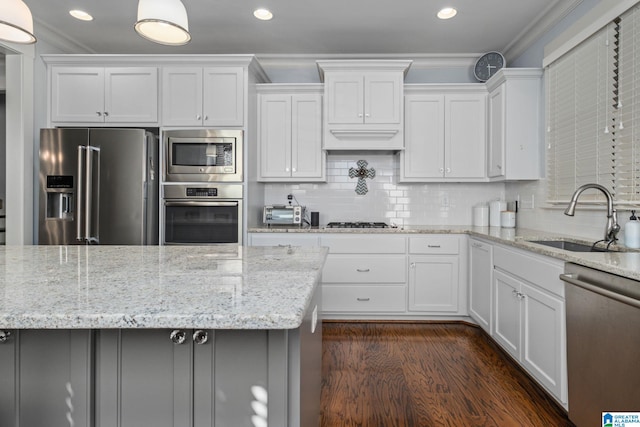 kitchen with ornamental molding, sink, white cabinetry, and stainless steel appliances