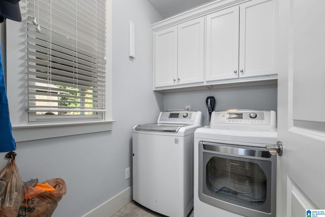 washroom featuring cabinets and washer and clothes dryer