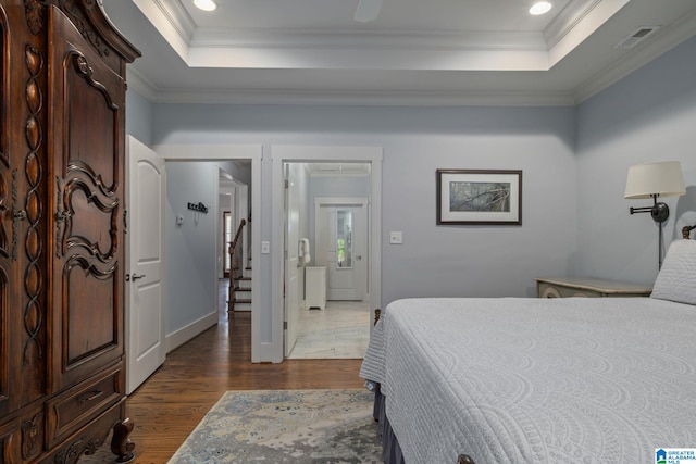 bedroom with a raised ceiling, ornamental molding, and dark hardwood / wood-style floors