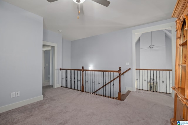 hall with vaulted ceiling and light colored carpet