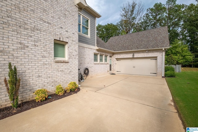 view of property exterior with a yard and a garage