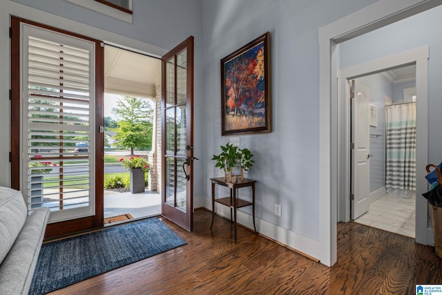 foyer entrance with ornamental molding and dark hardwood / wood-style flooring