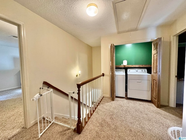 washroom featuring carpet, a textured ceiling, and separate washer and dryer