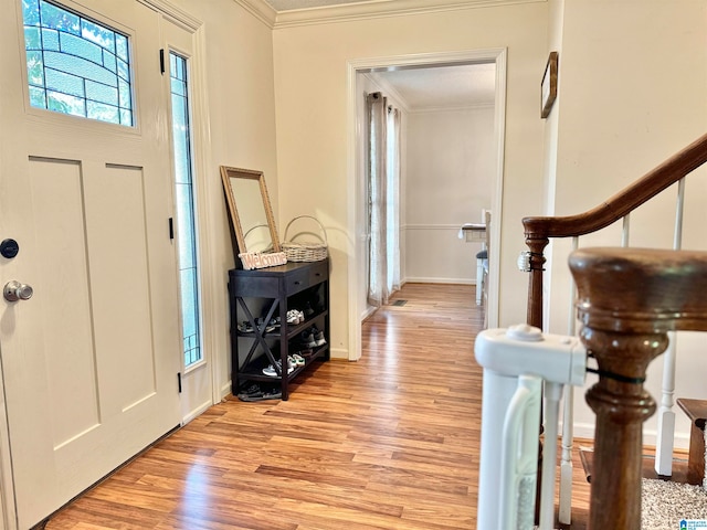 entrance foyer with ornamental molding and light hardwood / wood-style floors