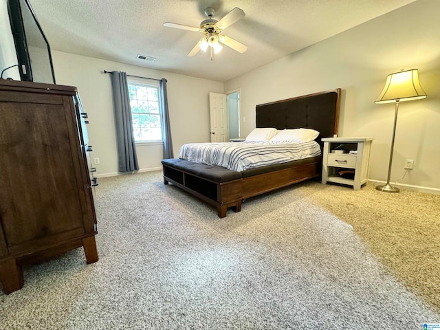 carpeted bedroom with a textured ceiling and ceiling fan