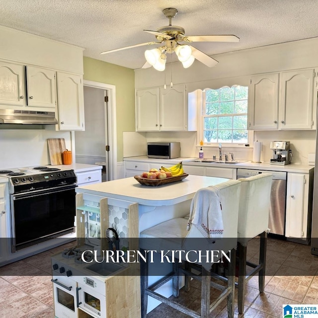 kitchen featuring a textured ceiling, white cabinetry, stainless steel appliances, and ceiling fan