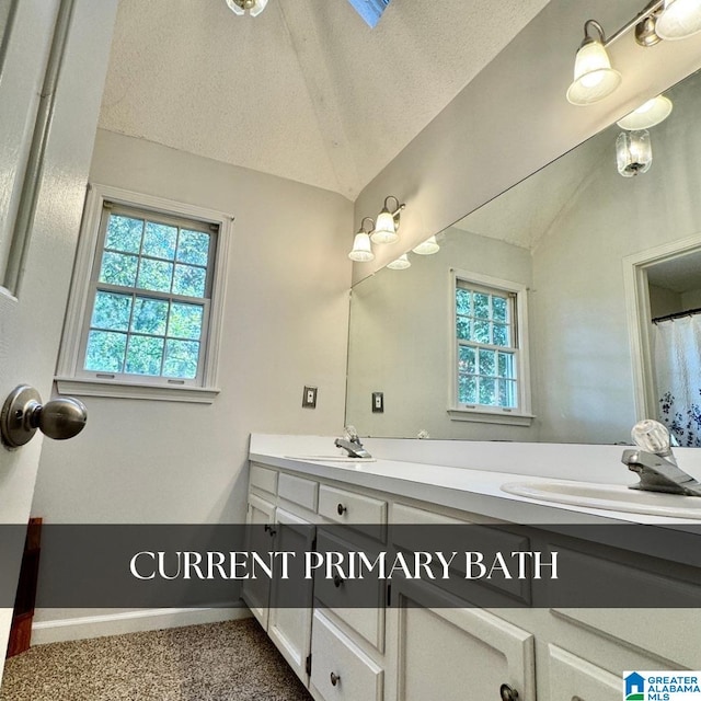 bathroom featuring vanity, lofted ceiling, and a textured ceiling