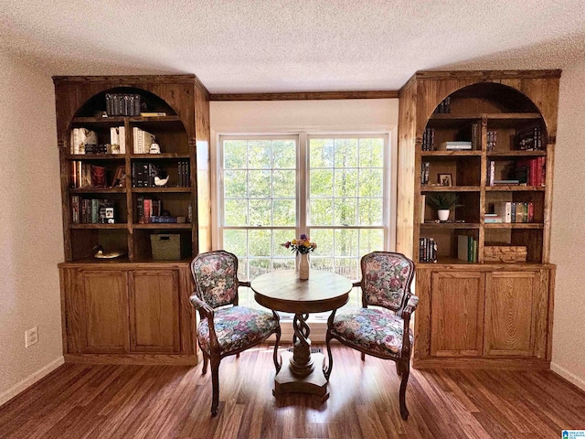 sitting room featuring a textured ceiling, crown molding, and hardwood / wood-style flooring