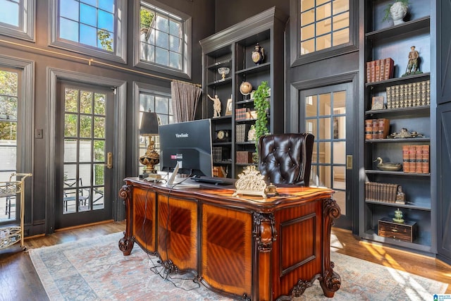 office space with a towering ceiling and hardwood / wood-style floors