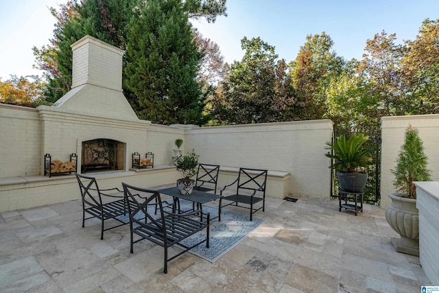 view of patio / terrace featuring an outdoor brick fireplace