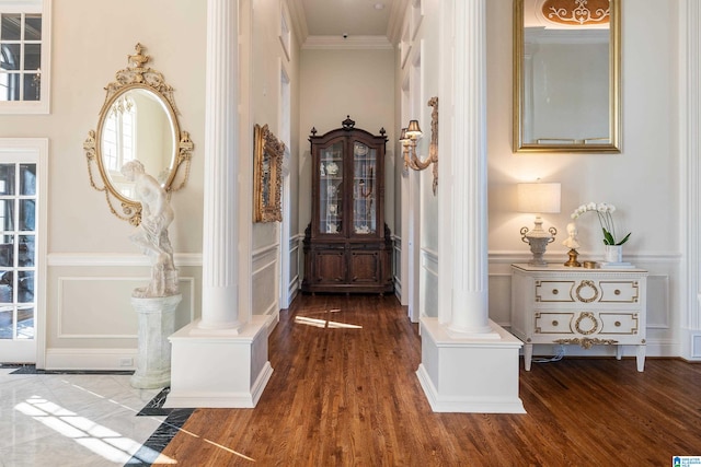 corridor with crown molding, dark hardwood / wood-style floors, and ornate columns