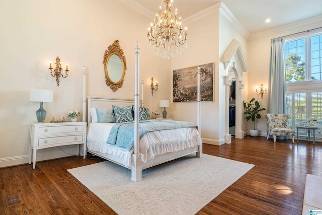 bedroom with ornamental molding, dark hardwood / wood-style flooring, a chandelier, and a high ceiling