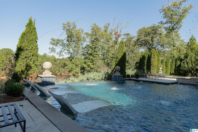 view of swimming pool featuring a hot tub and pool water feature