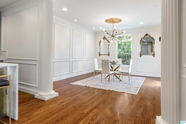 dining area featuring decorative columns, a notable chandelier, ornamental molding, and dark hardwood / wood-style flooring