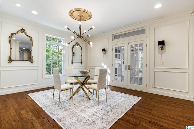 dining space featuring french doors, crown molding, dark hardwood / wood-style flooring, and a chandelier