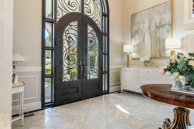 entrance foyer featuring french doors and a high ceiling