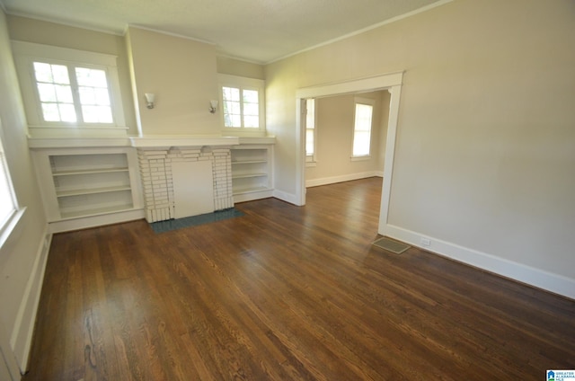 unfurnished living room with a wealth of natural light, a brick fireplace, and dark hardwood / wood-style flooring