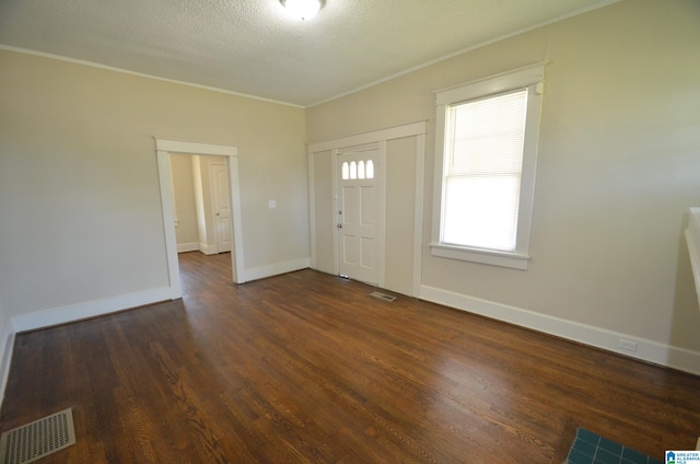 foyer with crown molding, dark hardwood / wood-style floors, and a textured ceiling