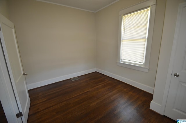 spare room with ornamental molding, a healthy amount of sunlight, and dark hardwood / wood-style flooring