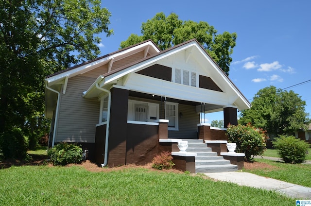 view of front of home with covered porch and a front lawn