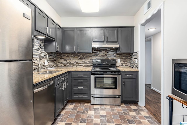 kitchen featuring tasteful backsplash, sink, stainless steel appliances, gray cabinets, and light stone counters