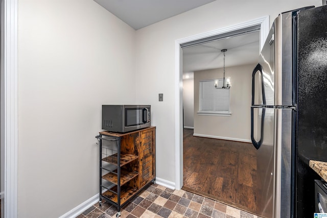 kitchen with appliances with stainless steel finishes, dark hardwood / wood-style floors, and hanging light fixtures