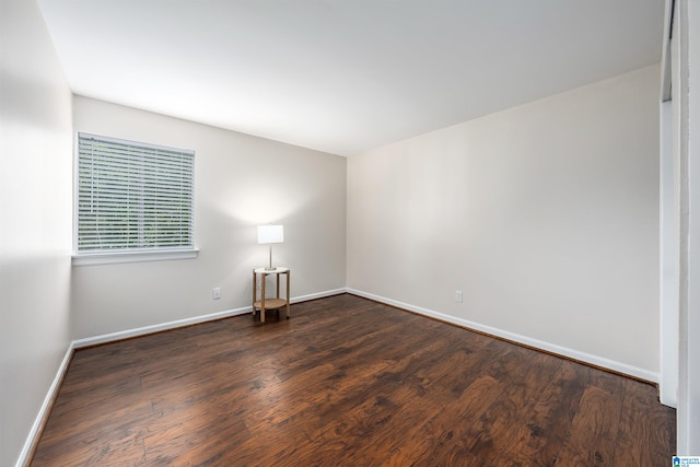 unfurnished room with dark wood-type flooring