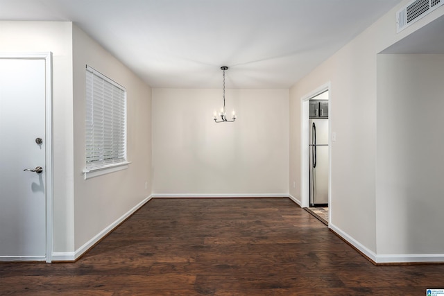 unfurnished dining area featuring dark wood-type flooring and an inviting chandelier