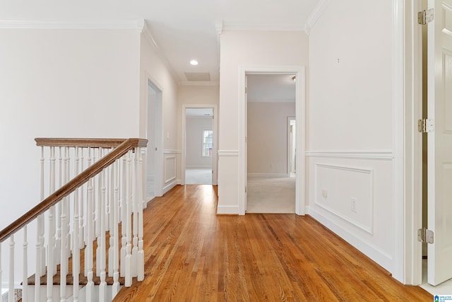 hallway with crown molding and light hardwood / wood-style flooring