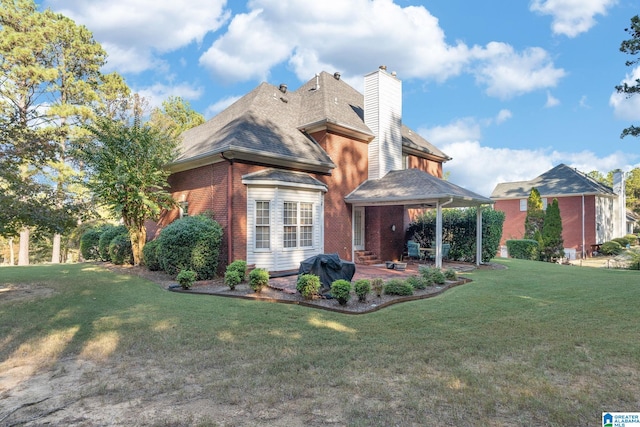 back of house with a patio and a yard