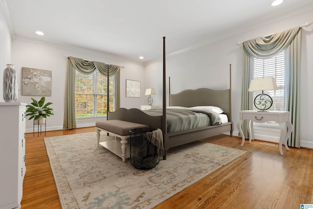 bedroom with hardwood / wood-style floors, multiple windows, and crown molding