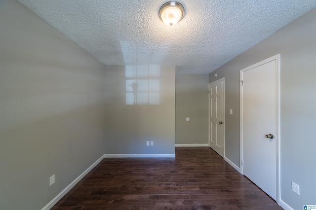 unfurnished room with dark wood-type flooring and a textured ceiling