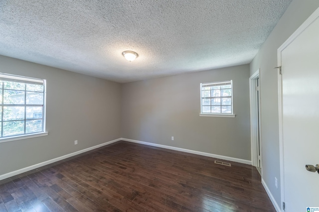 unfurnished room with a textured ceiling and dark wood-type flooring