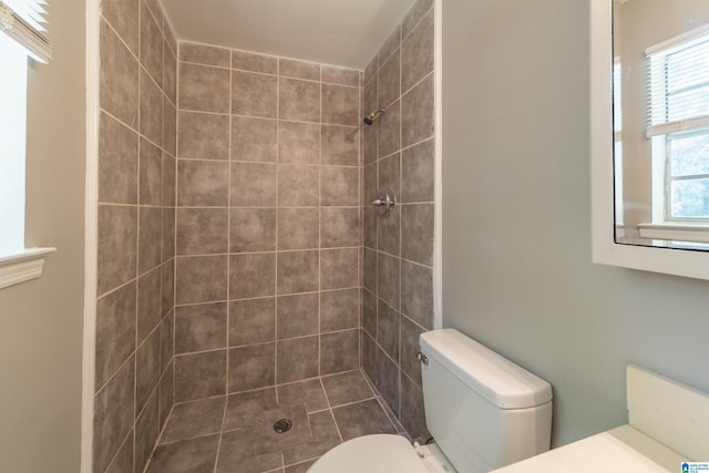 bathroom with toilet and tiled shower