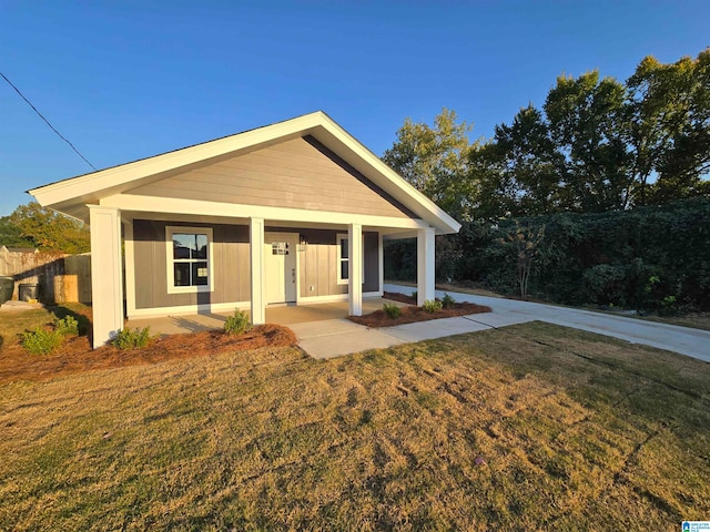 view of front of home with covered porch and a front lawn