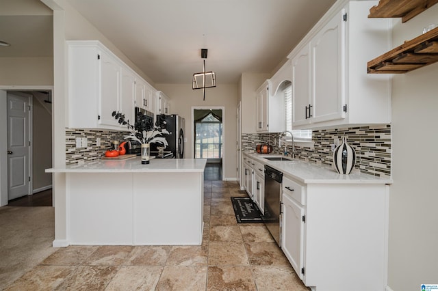 kitchen with appliances with stainless steel finishes, kitchen peninsula, white cabinets, and pendant lighting