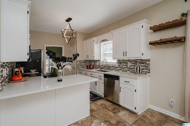 kitchen featuring kitchen peninsula, white cabinets, tasteful backsplash, stainless steel dishwasher, and decorative light fixtures