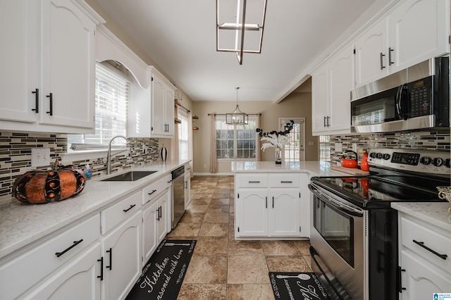 kitchen with white cabinetry, stainless steel appliances, a chandelier, and pendant lighting