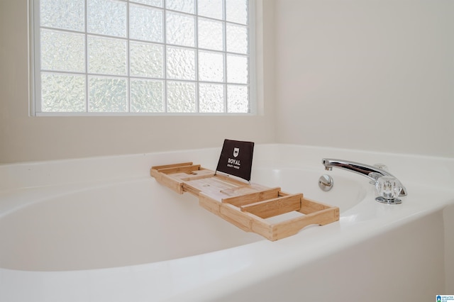 bathroom with a wealth of natural light and a bath