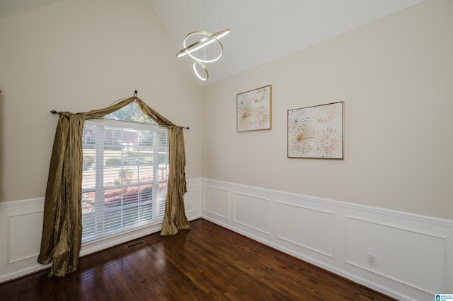 unfurnished dining area with vaulted ceiling, a notable chandelier, and dark hardwood / wood-style flooring