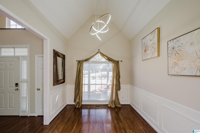 foyer entrance with high vaulted ceiling, dark hardwood / wood-style flooring, and a wealth of natural light