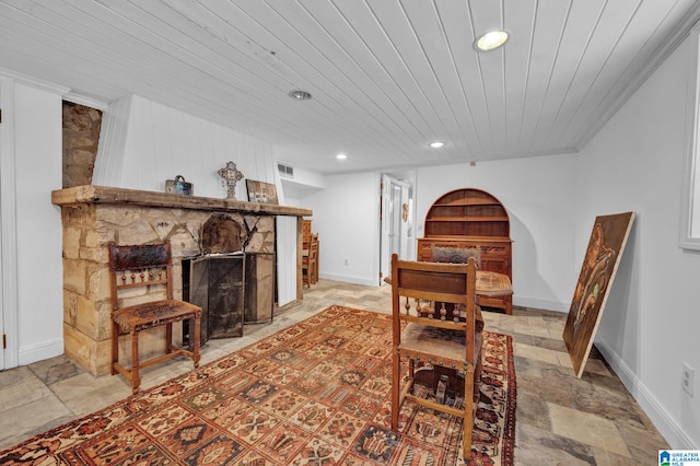 dining space featuring a fireplace and wooden ceiling