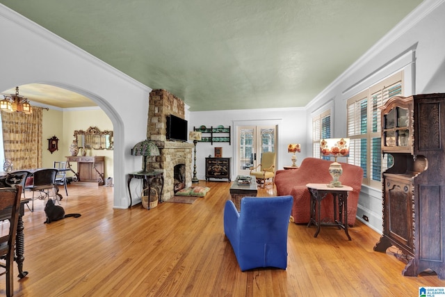 living room featuring ornamental molding, light hardwood / wood-style flooring, and a fireplace