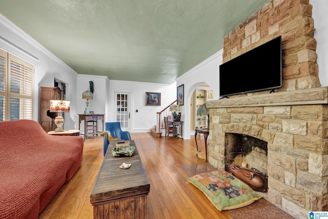 living room featuring crown molding, a fireplace, and wood-type flooring