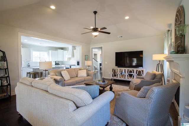 living room featuring lofted ceiling, ceiling fan, a fireplace, and dark hardwood / wood-style flooring