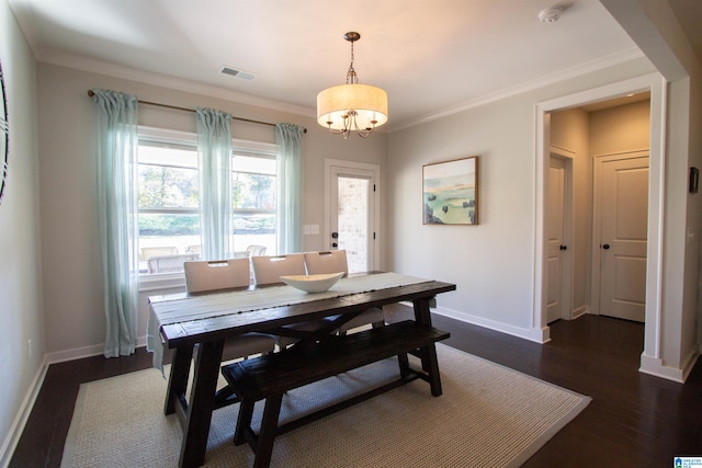 dining space featuring dark wood-type flooring, a notable chandelier, and ornamental molding