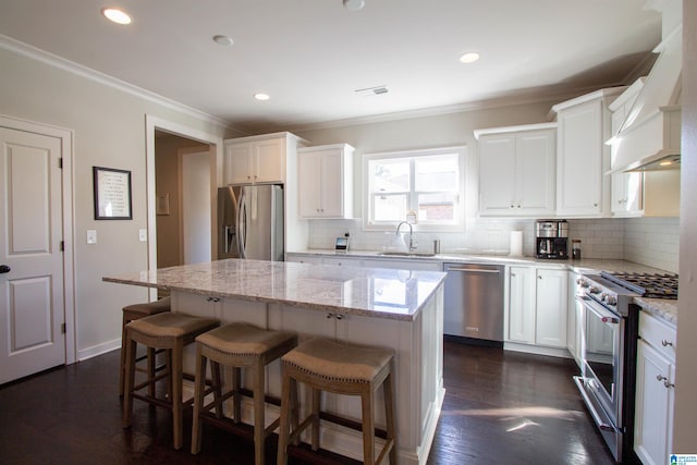 kitchen with sink, a center island, dark hardwood / wood-style flooring, stainless steel appliances, and white cabinets