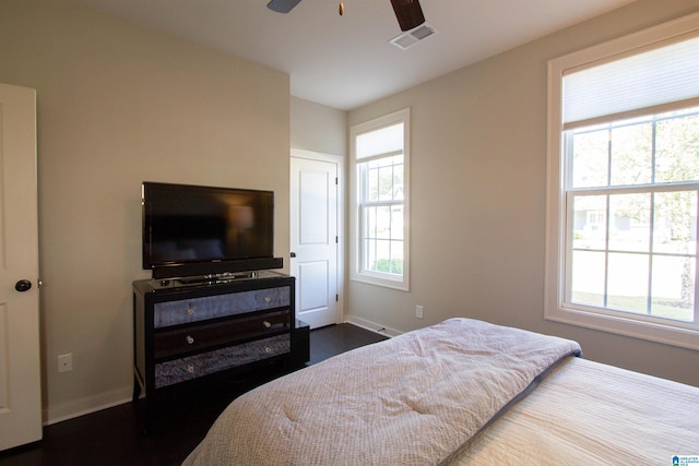 bedroom with hardwood / wood-style floors, multiple windows, and ceiling fan